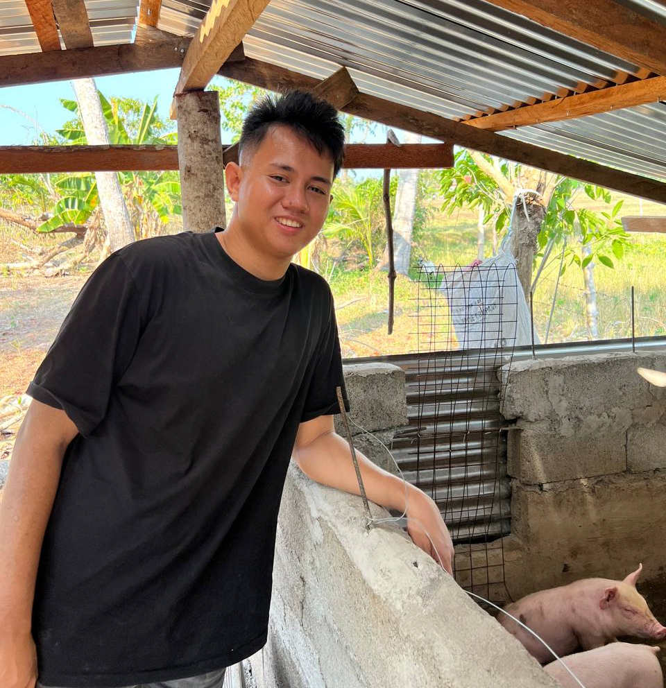 Owner of Papa G. Piggery feeding pigs in a backyard farm in Masbate